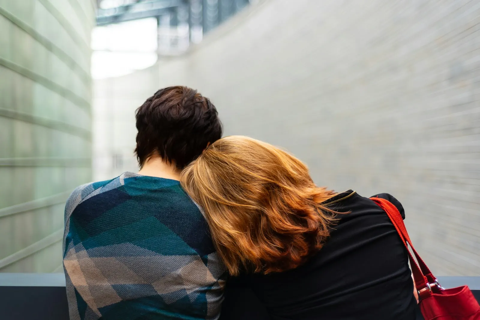 Woman resting her head on a friend's shoulder for comfort
