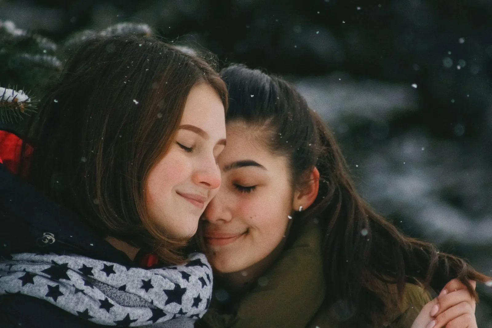 Two friends hugging warmly outdoors in winter