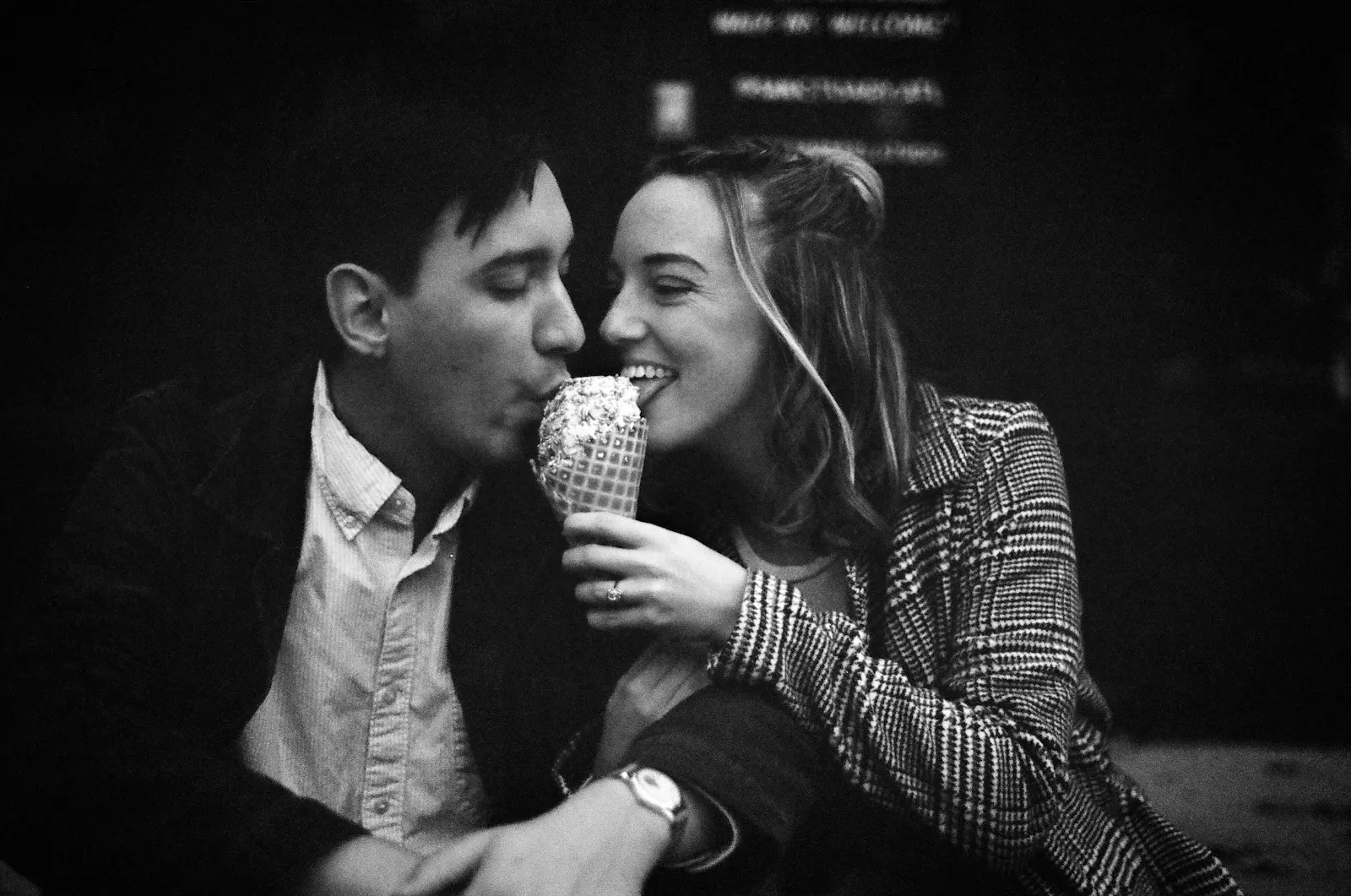 Black-and-white photo of a couple sharing an ice cream cone