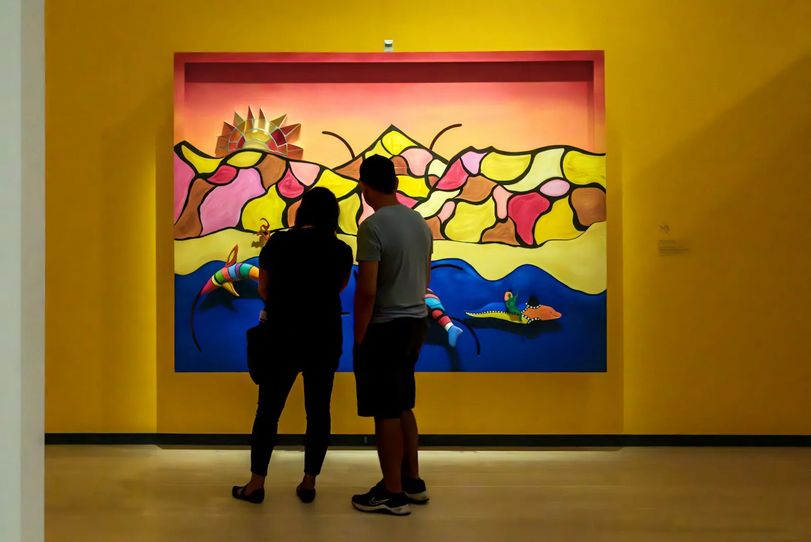 Couple looking at a colorful painting in an art gallery