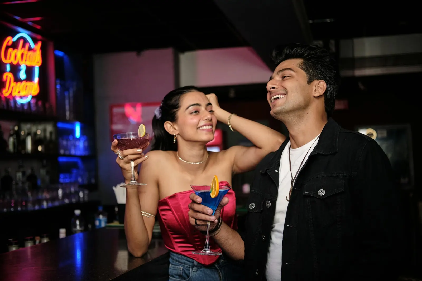 Man and woman laughing and flirting at a cocktail bar