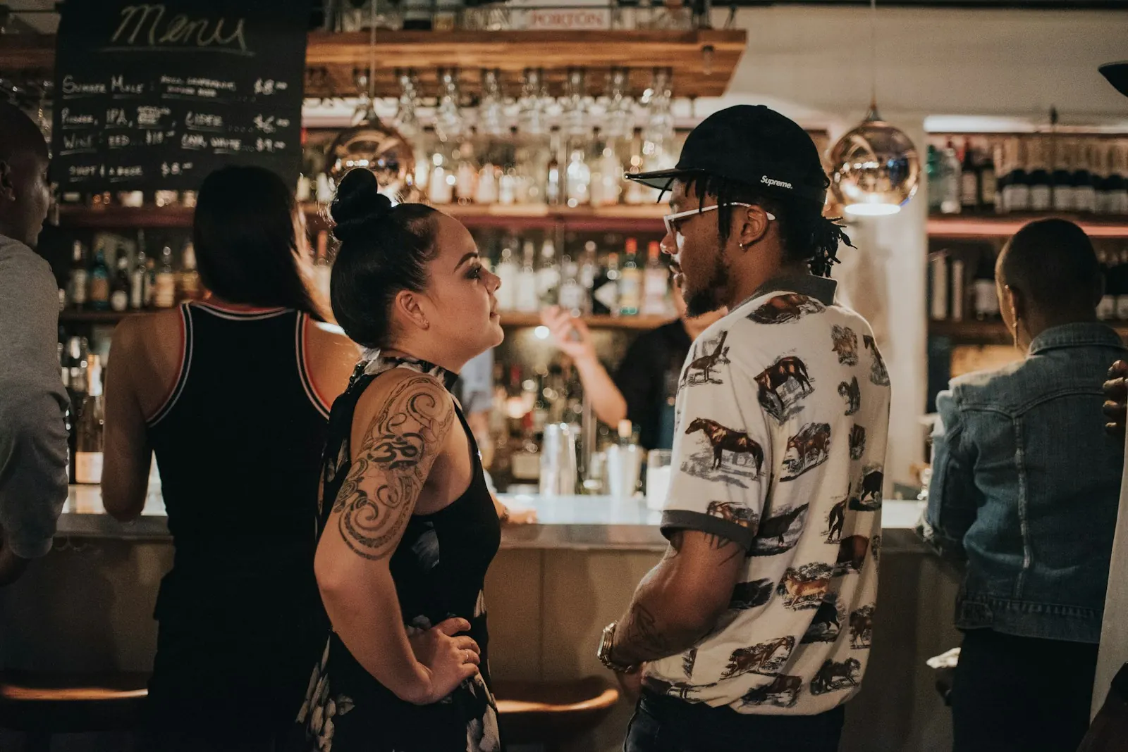 Man and woman chatting face to face at a busy bar