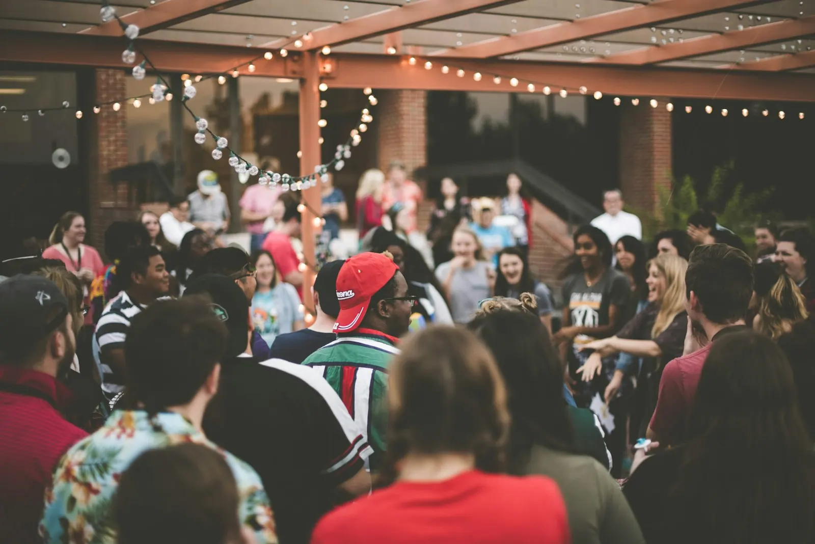 Crowd of people laughing and mingling at an evening party