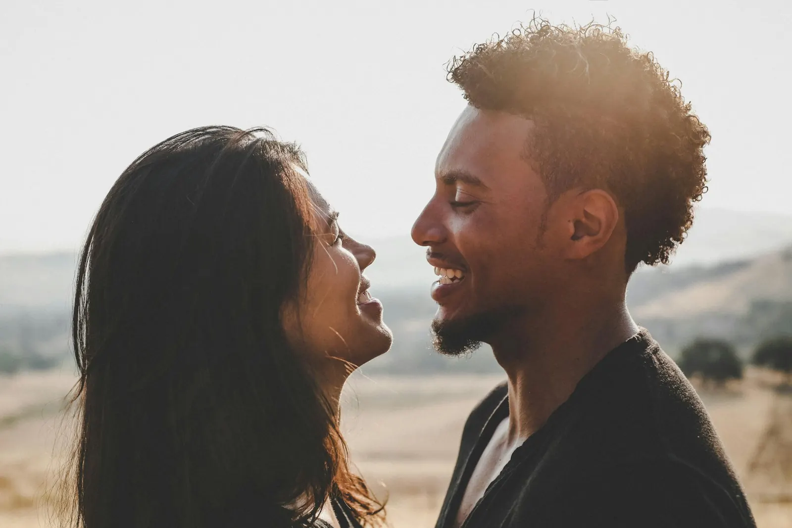 Couple smiling and talking face to face outdoors