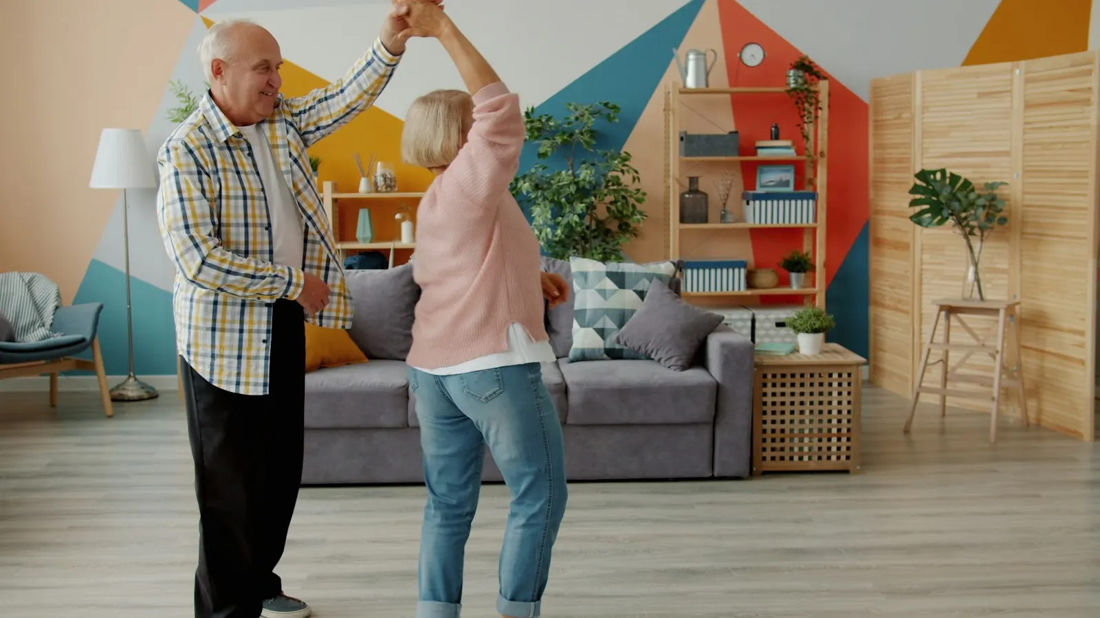 Older couple dancing joyfully in their living room